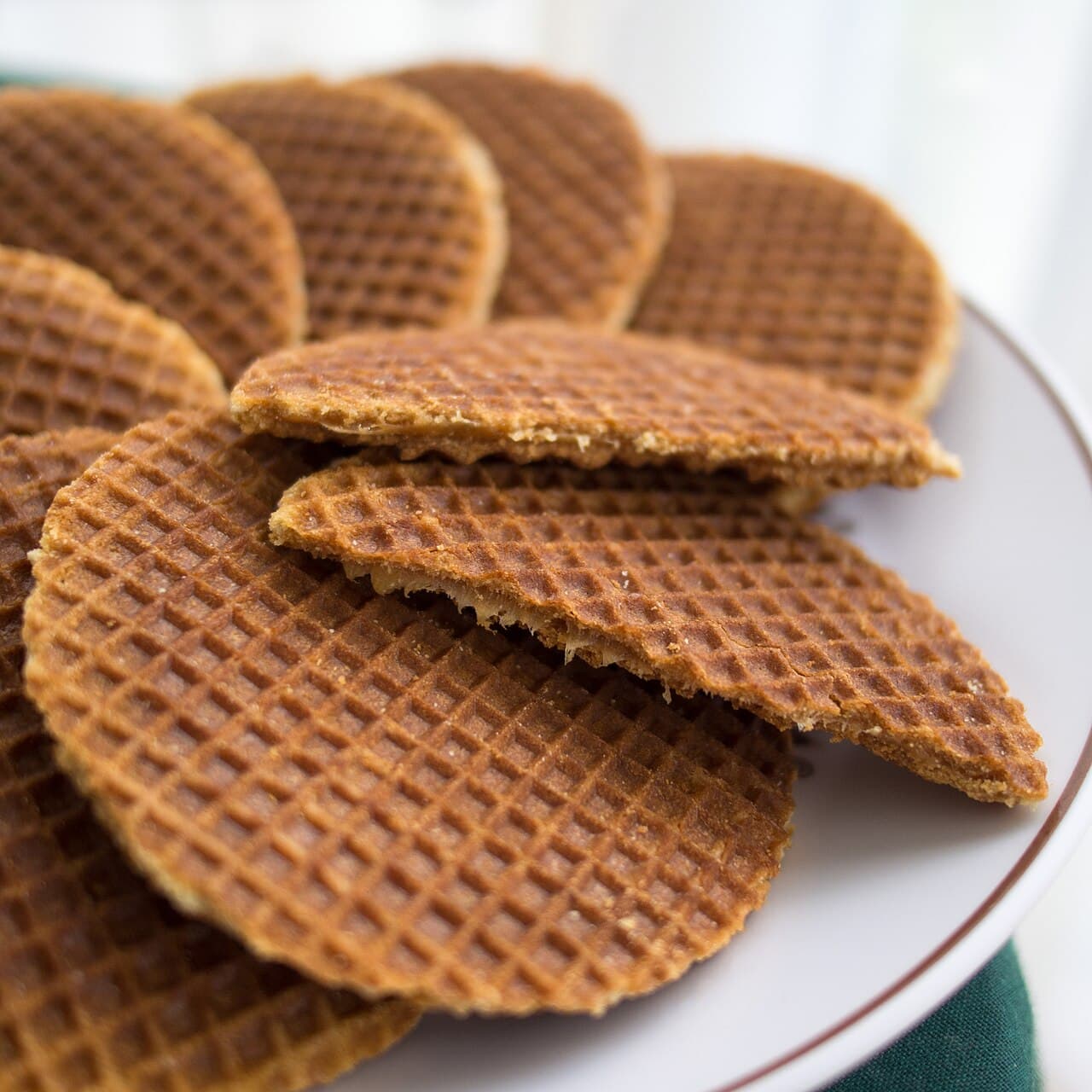 A fresh stroopwafel being pressed on a waffle iron at a market stall
