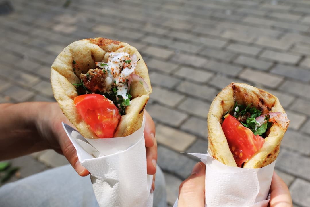 A souvlaki pita wrap with grilled meat, tzatziki and tomatoes in paper