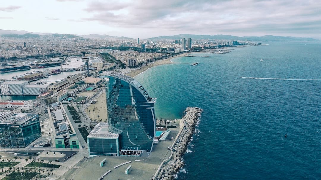 Barceloneta beach curving toward the W hotel's sail silhouette