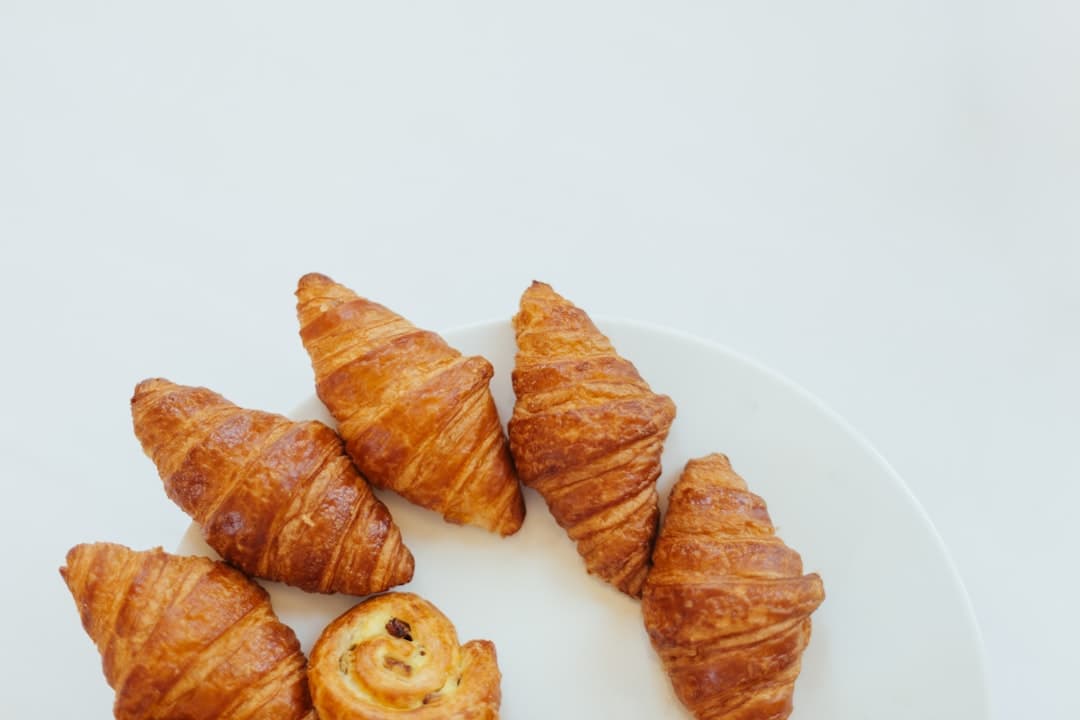 Golden layered croissants stacked in a bakery window