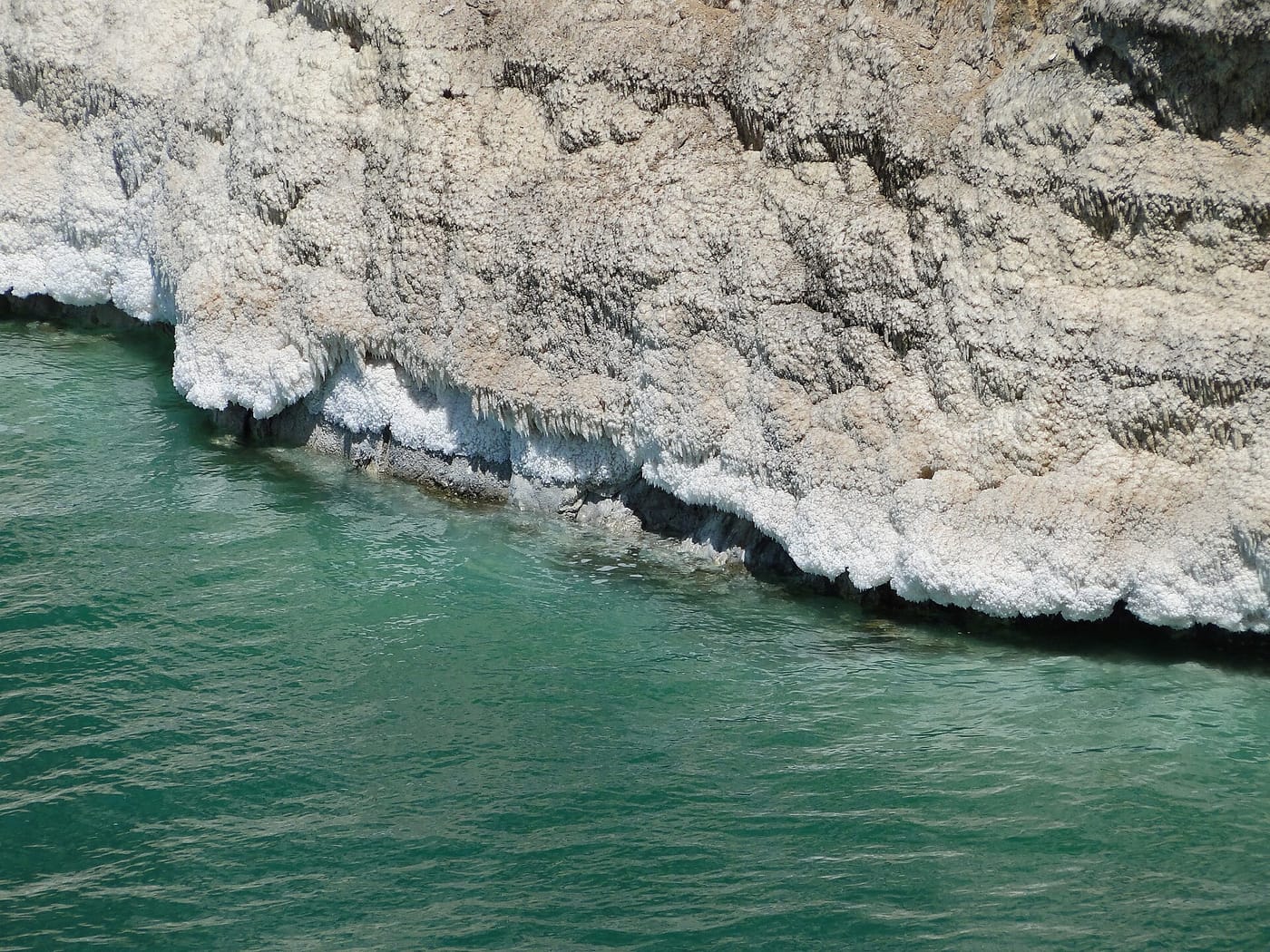 The salt-encrusted turquoise shore of the Dead Sea in Jordan