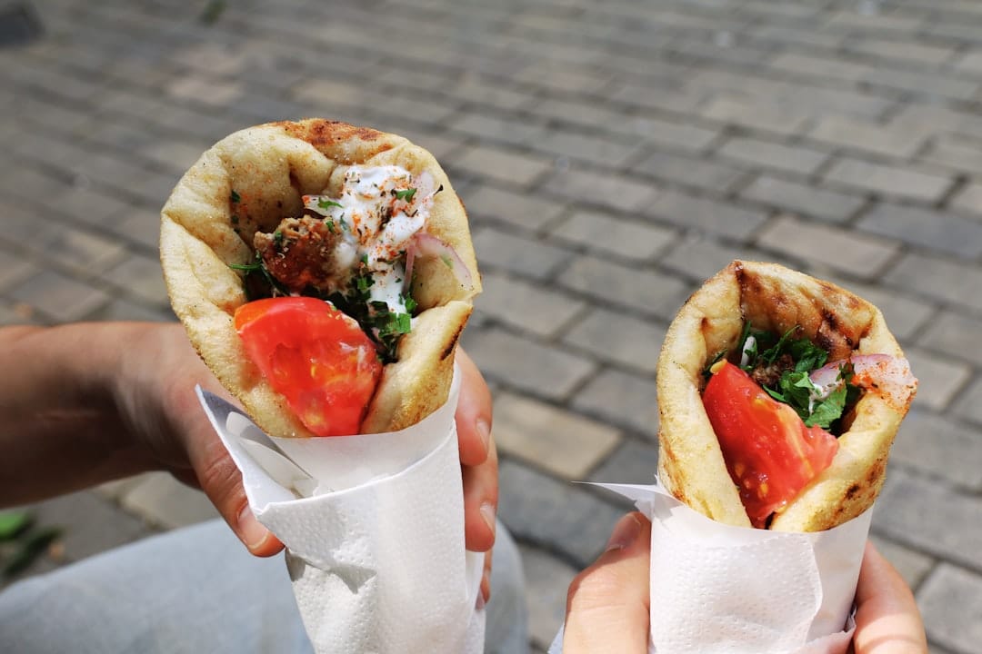A souvlaki pita wrap with grilled meat, tzatziki and tomatoes in paper