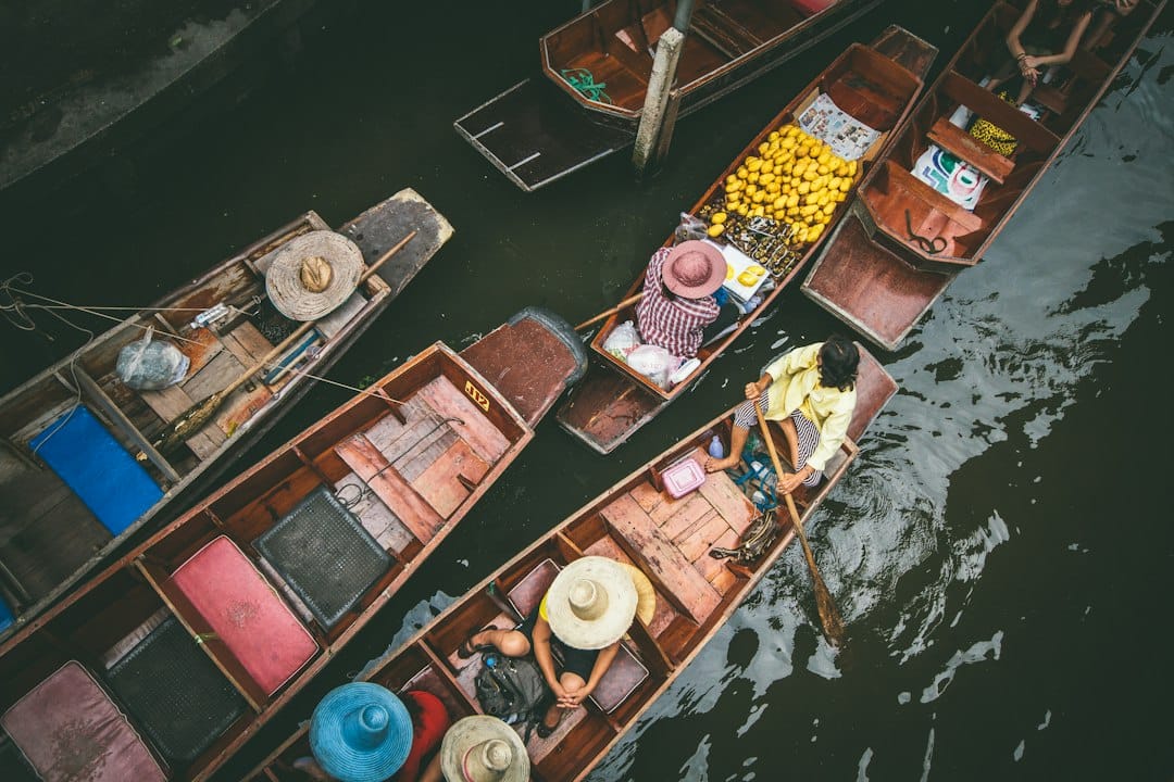 Wooden boats loaded with fruit at a Thai floating market seen from above