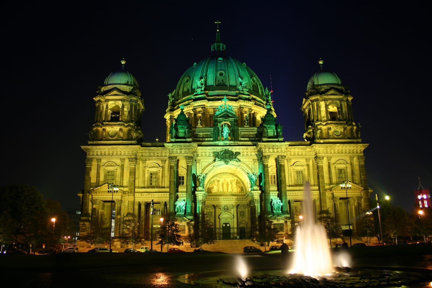 The Berliner Dom cathedral floodlit at night beside the Spree