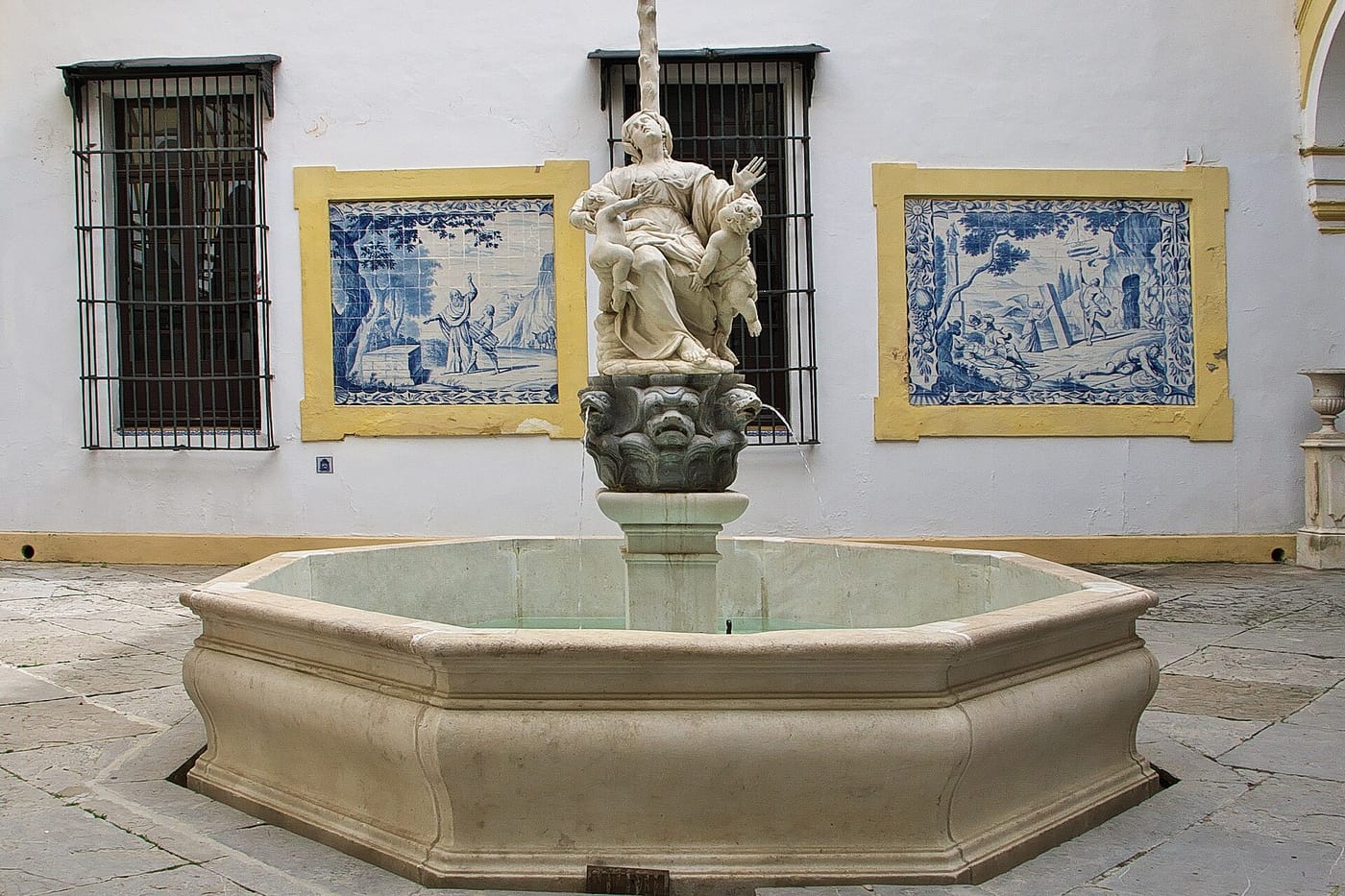 A tiled courtyard with a fountain at the Hospital de la Caridad in Seville