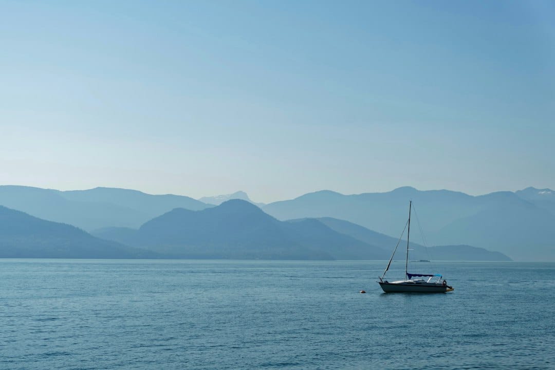 A sailboat on Howe Sound below the mountains on the Sea to Sky corridor